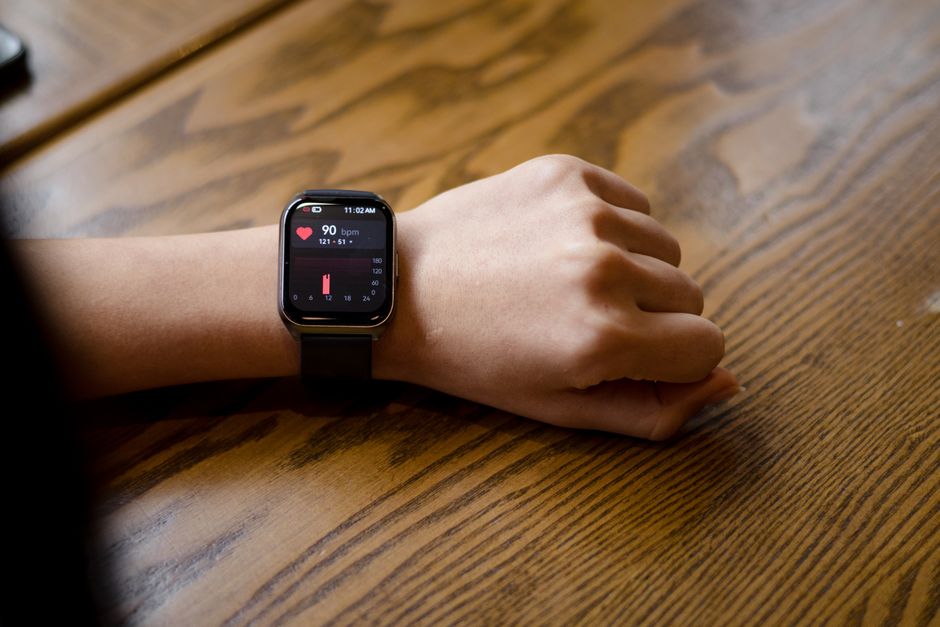 Smartwatch na nadgarstku wyświetlający aktualny pomiar tętna 90 bpm